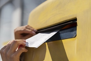 close up woman at mailbox with envelope